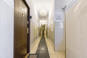 a hallway with doors and a chandelier at Waldmüller Apartments Vienna in Vienna