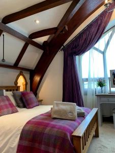 a bedroom with a large bed with purple curtains at The Old School - Beautiful School House, quiet location near the coast in Laugharne