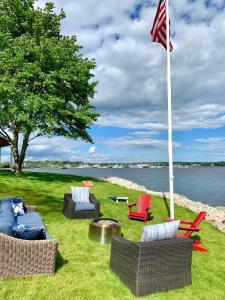 a group of chairs and a flag in the grass at Harbor View Landing in Mystic