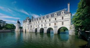 a large building in the water with a bridge at Camping de Montlouis-sur-Loire in Montlouis-sur-Loire