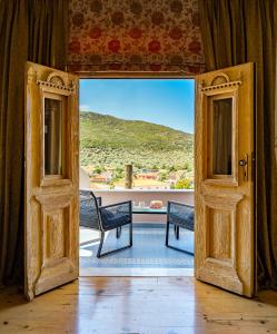 una porta aperta su un balcone con tavolo e sedie di Aegean sea view luxury residence Thassos a Prinos