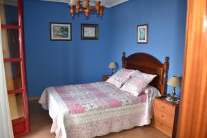 Dormitorio azul con cama y pared azul en Hotel Imperial, en Tazones