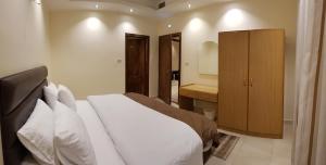 1 Schlafzimmer mit einem großen Bett und einem Badezimmer in der Unterkunft Marmaris Hotel Apartments in Amman