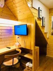 een hut met een bureau en een tv aan de muur bij Blu Cabin Gay Poshtel in Bangkok