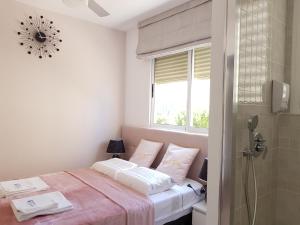 een slaapkamer met een bed met 2 kussens en een raam bij Apartamento Elizabeth in Gandía