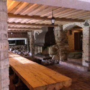 a large stone room with a wooden table and an oven at Kreisā Impērija in Riga