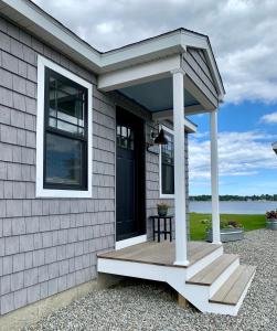 a front porch of a house with a black door at Harbor View Landing in Mystic