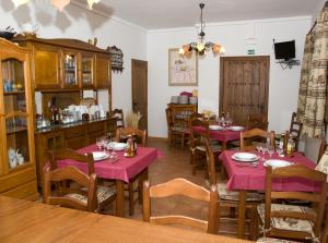 een eetkamer met tafels en stoelen met roze tafelkleden bij Casa Rural SPA El Rincón de Palmacio in Pálmaces de Jadraque