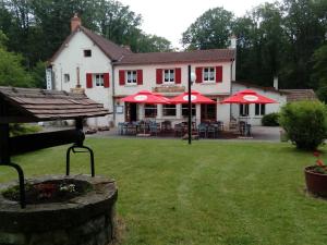 a house with red umbrellas in a yard at le rond gardien in Isle-et-Bardais