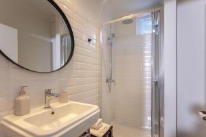 a white bathroom with a sink and a shower at Dousmani Corfu Old Town Studio Suite in Corfu Town +23 photos
