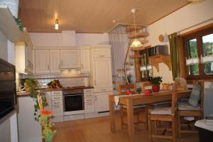 eine Küche mit weißen Schränken und einem Holztisch in der Unterkunft Biohof Schad in Eisenbach