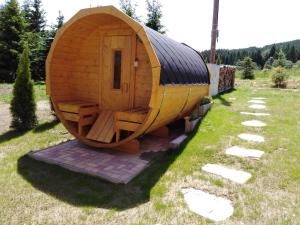 una pequeña casa hobbit de madera en el césped en Chalupy Vichrovky en Bělá pod Pradědem