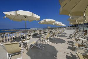 een rij stoelen en parasols op een strand bij Residence Villa Piani in San Vincenzo