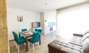 comedor y sala de estar con mesa y sillas en Apartamentos Castelo en Póvoa de Varzim