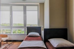 2 Betten in einem Zimmer mit 2 Fenstern in der Unterkunft Rooms with Fortetsya View 2 in Kamjanez-Podilskyj