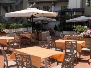 um pátio ao ar livre com mesas, cadeiras e guarda-sóis em Hotel Pineta Palace em Roma mais 35 fotografias
