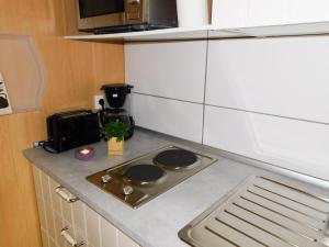 a kitchen counter with a stove and a microwave at Ferienwohnungen Landleben in Kammerforst +36 photos