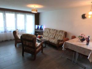 ein Wohnzimmer mit einem Sofa, Stühlen und einem Tisch in der Unterkunft Haus Erle in Saas-Grund