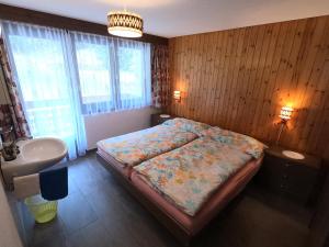 Schlafzimmer mit einem Bett, einem Waschbecken und einem Waschbecken in der Unterkunft Haus Erle in Saas-Grund