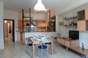 eine Küche und ein Esszimmer mit einem Tisch und Stühlen in der Unterkunft Appartamento La Poesia Luxury - MyHo Casa in Tortoreto Lido
