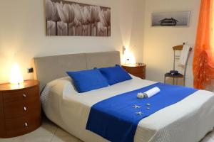 a bedroom with a large bed with blue pillows at Appartamento La Poesia Luxury - MyHo Casa in Tortoreto Lido