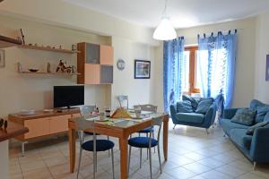 cocina y sala de estar con mesa y sillas en Appartamento La Poesia Luxury - MyHo Casa en Tortoreto