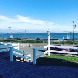 a white fence next to the ocean with a street light at Oceanside Condos in Dennis Port