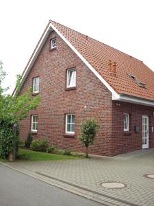 une maison en briques rouges avec un toit blanc dans l'établissement Bontemps Apartment, à Timmendorfer Strand