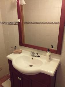 ein Badezimmer mit einem weißen Waschbecken und einem Spiegel in der Unterkunft Casa la Era in Salas Bajas