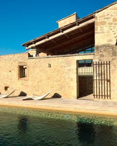 a building with two white sculptures next to a body of water at Les Toiles du 15 in Montaren-et-Saint-Médiers