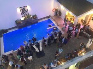 a crowd of people standing around a swimming pool at Hotel Chipiona in Chipiona