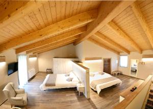 2 letti in una camera con soffitti in legno di Agr. Cascina Fabbrica a Fossano