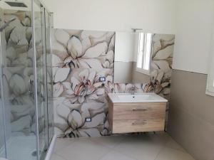 a bathroom with a shower and a sink with a flower mural at Residence Tre Gemme in Trapani