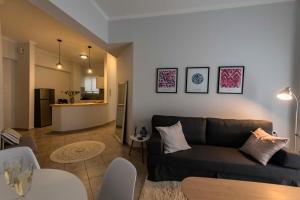 salon z kanapą i stołem w obiekcie Avra Apartment w Kalamácie
