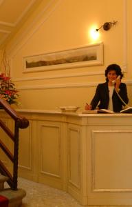 a woman sitting at a counter talking on a phone at Residence Michelangiolo in Florence
