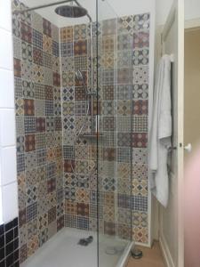 een douche met een glazen deur in de badkamer bij Villa Josephine in Quinsac