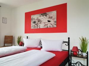 two beds in a room with red and white at XXL-Ferienwohnung Blumenwiese in Hayingen