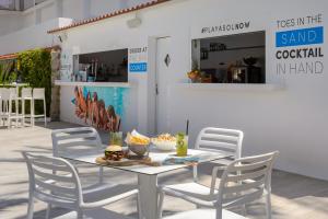 einen weißen Tisch mit Stühlen und ein Sandwich drauf in der Unterkunft Hotel Vibra Marco Polo I - Adults only in Sant Antoni de Portmany
