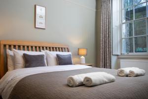 1 dormitorio con 1 cama grande y toallas. en Stunning Royal Crescent Apartment with 3 Bedrooms en Bath