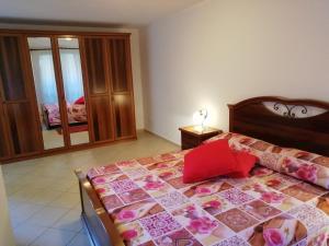 a bedroom with a bed with a red pillow on it at Appartamento Joanna in Nurachi