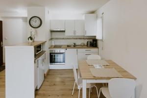 een keuken met een houten tafel en witte kasten bij Appartement 4 personnes jardin et parking in Vannes