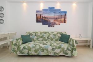 a couch in a living room with a painting on the wall at Green paradise T2 apartment with pool top floor in Albufeira