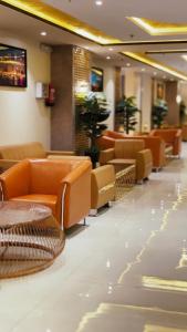 a waiting room with orange furniture in a building at Borj Al Thahabiah ApartHotel in Taif