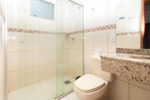 ein Badezimmer mit Toilette und Glasdusche in der Unterkunft Turis Hotel Centro in Campo Grande