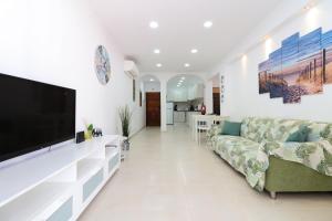 a living room with a couch and a flat screen tv at Green paradise T2 apartment with pool top floor in Albufeira
