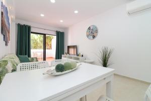 a white living room with a table and a couch at Green paradise T2 apartment with pool top floor in Albufeira