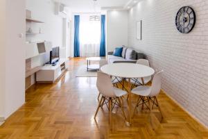 sala de estar con mesa y sillas en Grove Apartment + Free Parking, en Novi Sad