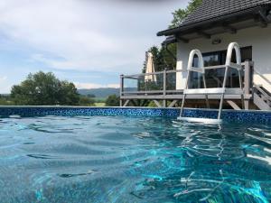 una piscina con una silla y una casa en Chata Prachov****, en Jičín