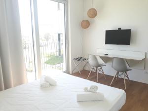 a white bedroom with a white bed and a desk at Luna Blu in La Spezia