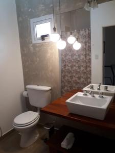 a bathroom with a white toilet and a sink at Las Toscas Apart in Curuzú Cuatiá +23 photos